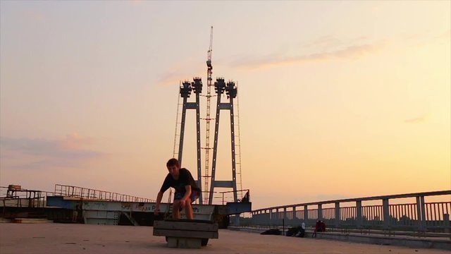 roller make trick on bridge on sunset