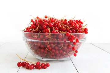 Fresh red currant on the light wooden background