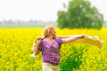 The beautiful woman dances on a rape field