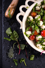 Diet salad, fresh tomato and mozzarella in rustic bowl
