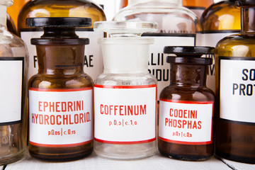 Bottle with caffeine among other vintage medicine bottles on woo