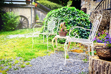 Decorative chairs in summer backyard garden - 86957004