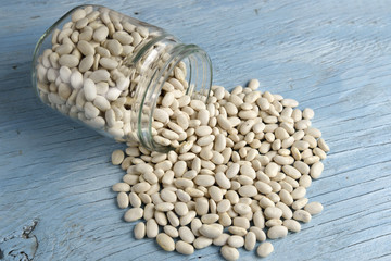 Jar of white beans on old wooden table