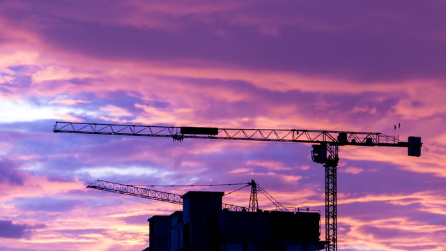 Silhouette Crane Working In Construction Site And Twilight Sky
