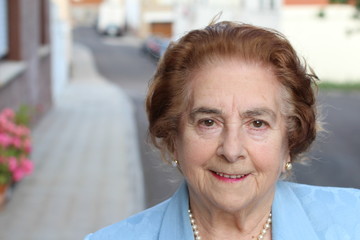 Portrait of an aged woman smiling outdoors