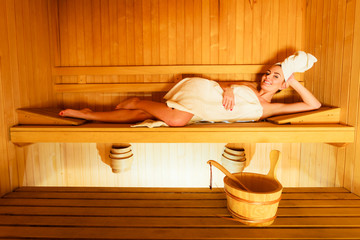 woman lying relaxed in wooden sauna
