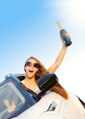 Happy woman driver with champagne