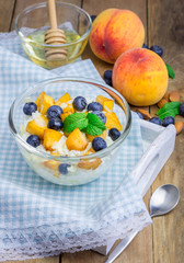Fresh cottage cheese with peach, blueberry, almonds and honey. Concept of healthy eating for breakfast.