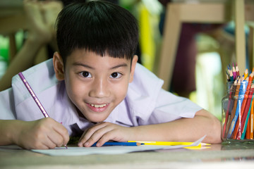 Happy asian boy painting and drawing  at home