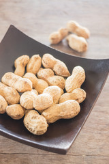 Salted peanuts on wooden bowl