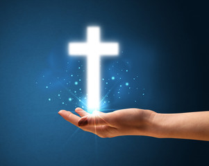 Glowing cross in the hand of a woman