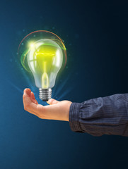 Glowing lightbulb in the hand of a woman