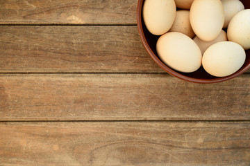 Egg in dish on old wooden table background.
