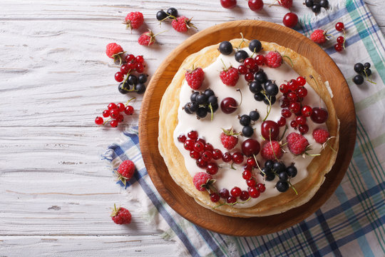 stack of crepes with berries and cream horizontal top view
