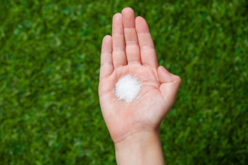 Human hand holding crystal sugar close up