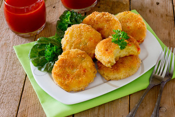 Vegetable burgers made from potatoes, corn and green peas on a wooden table