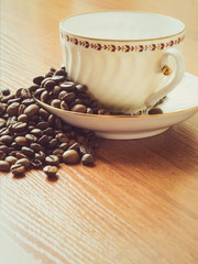 Cup with saucer and coffee beans on the table