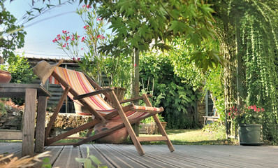chaise longue dans jardin sur terrasse en bois 