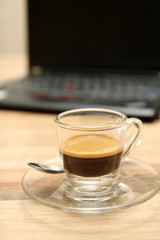 Cup of espresso coffee with laptop