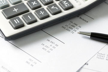 Financial statement with calculator and pen