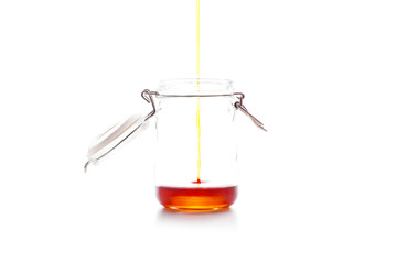 Honey Falling into Mason Jar Isolated on White Background. 