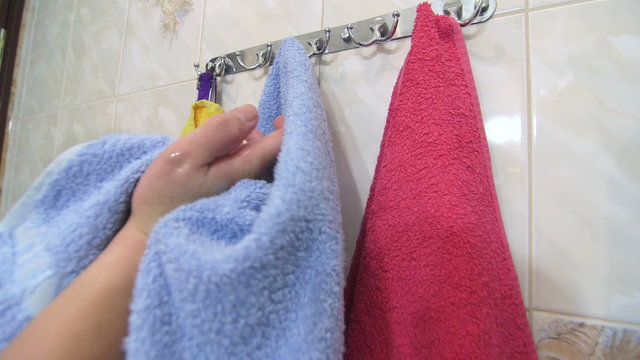 Woman drying hands with towel after washing in bathroom