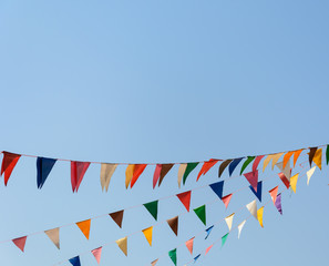 colorful festive bunting flags against a blue sky background