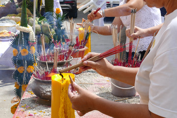 The woman is incensing bundle of joss stick