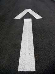 Asphalt road with a drawn direction arrow