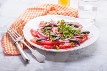 Grapefruit salad with olives, red onion, basil