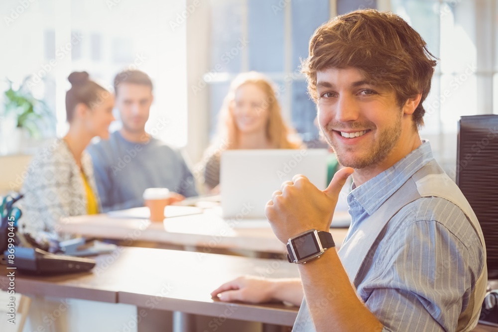 Wall mural Portrait of smiling young businessman with colleagues 