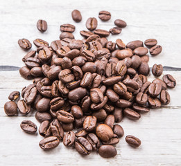 Roasted coffee beans over rustic wooden background