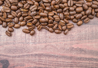Roasted coffee beans over rustic wooden background