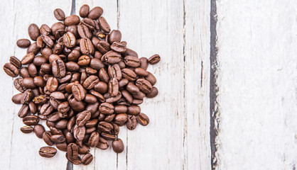 Roasted coffee beans over rustic wooden background
