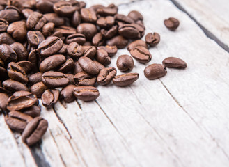Roasted coffee beans over rustic wooden background