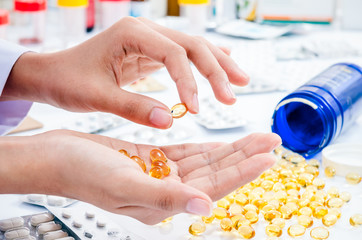 woman’s hands holding out fish oil pill 