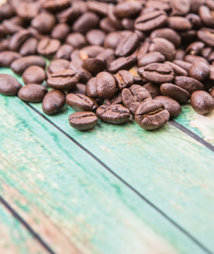 Roasted coffee beans over rustic wooden background