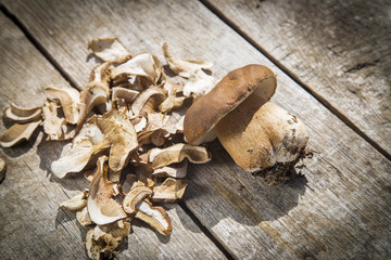Boletus Edilus mushroom on a wooden table  – fresh and dried