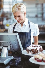  Smiling employee using calculator on counter