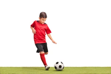 Foto op Canvas Little kid kicking a football © Ljupco Smokovski