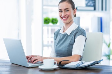 Happy businesswoman working on laptop computer