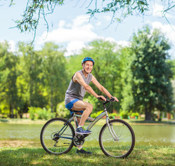 Naklejka premium Senior biker riding a bike in park
