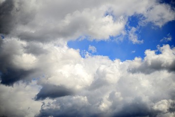 Obraz premium Big fluffy white and dark clouds in the blue sky