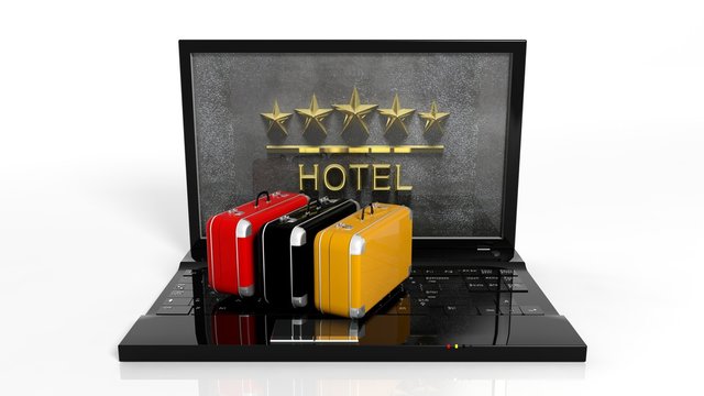Suitcases on laptop keyboard with 5 stars hotel symbol on screen