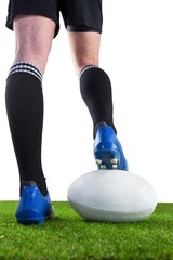 Rugby player posing feet on the ball