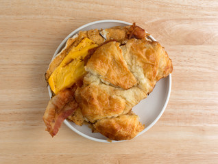 Bacon egg and cheese croissant breakfast sandwich on plate