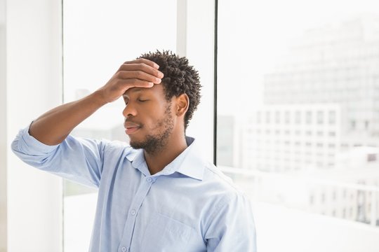 Young Concentrating Businessman Leaning Against The Wall