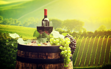 Obraz na płótnie Canvas Red wine bottle and wine glass on wodden barrel. Beautiful Tusca