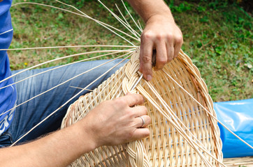 Man's hands making a wicker basket