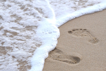 Footprints in the sand leading to the sea